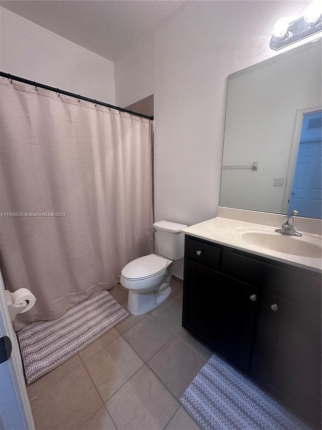 bathroom featuring tile patterned flooring, vanity, and toilet