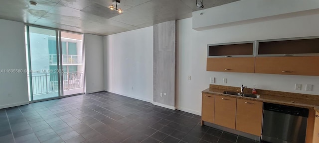 kitchen featuring expansive windows, stainless steel dishwasher, and sink