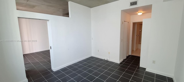 spare room featuring dark tile patterned floors