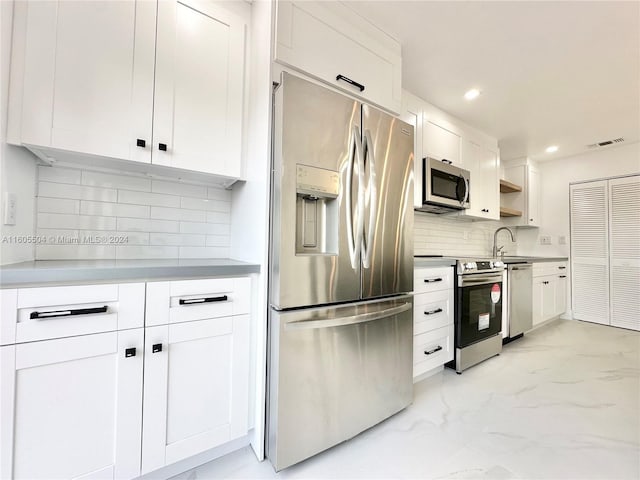 kitchen with white cabinets, backsplash, stainless steel appliances, and sink