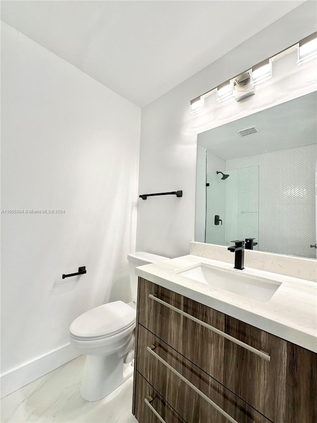 bathroom with a shower, vanity, and toilet