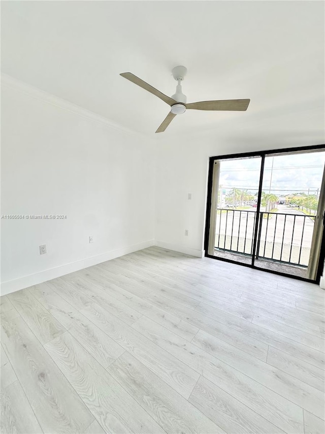 spare room featuring ceiling fan, crown molding, and light wood-type flooring