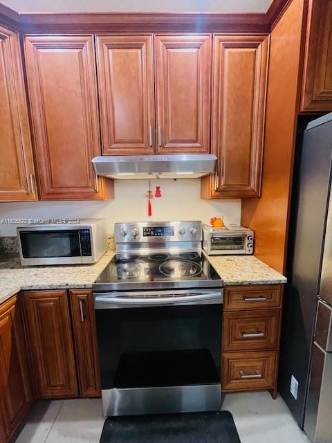 kitchen featuring appliances with stainless steel finishes and light stone counters