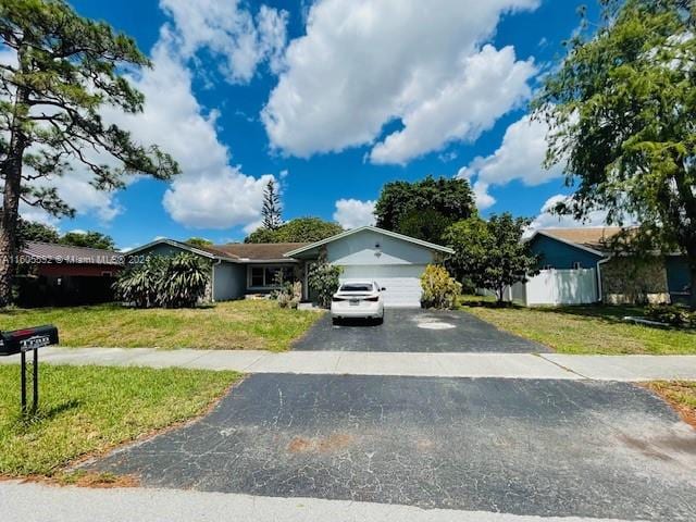 view of front of property featuring a garage and a front lawn