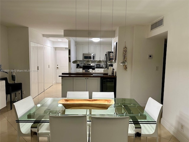 dining area with light tile patterned flooring, visible vents, and baseboards