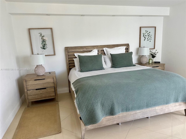 bedroom with light tile patterned floors and baseboards