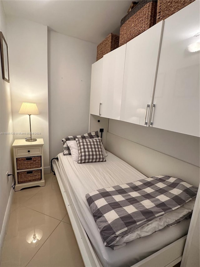 bedroom featuring light tile patterned floors and baseboards