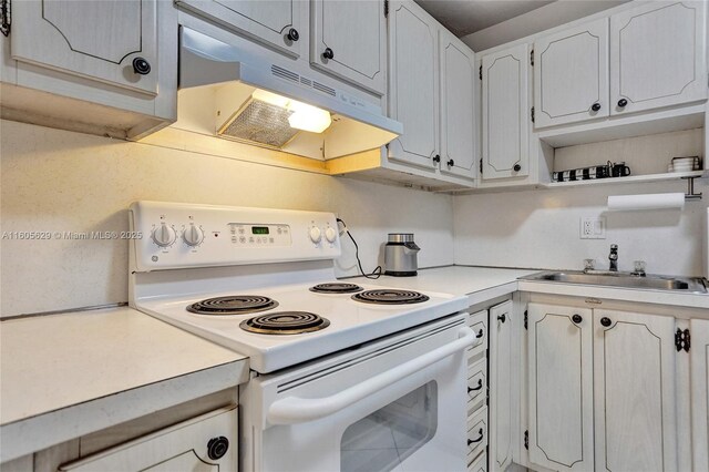 kitchen with white cabinets, white electric range oven, light tile patterned floors, and sink