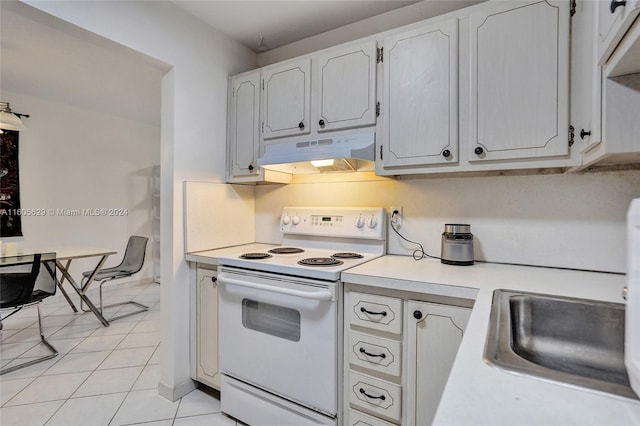 kitchen featuring electric stove, white cabinets, sink, and light tile patterned floors