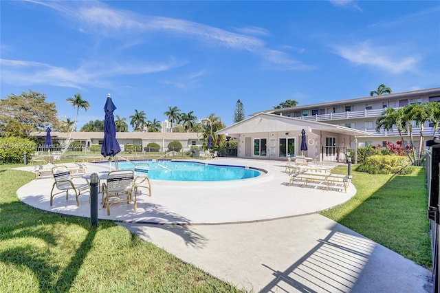 view of swimming pool with a patio area and a yard