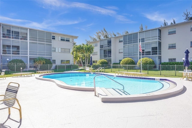 view of swimming pool featuring a lawn and a patio