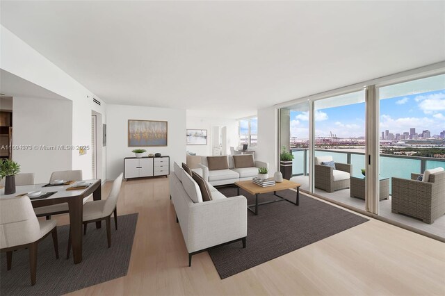 living room with a wealth of natural light, expansive windows, and wood-type flooring