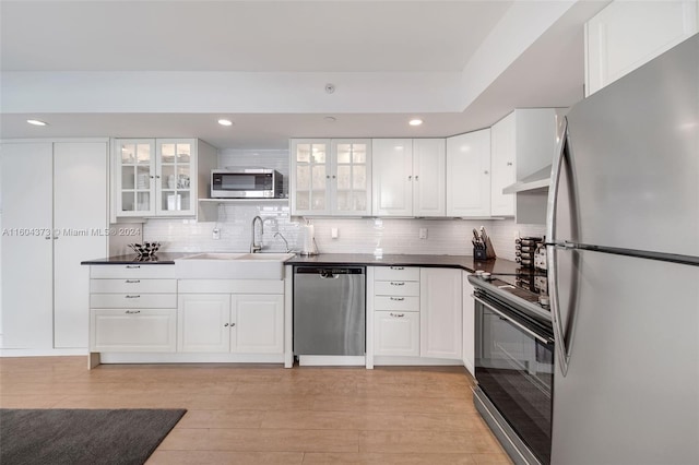 kitchen featuring white cabinets, sink, light wood-type flooring, and stainless steel appliances