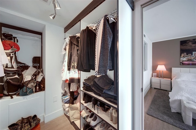 walk in closet with light hardwood / wood-style floors