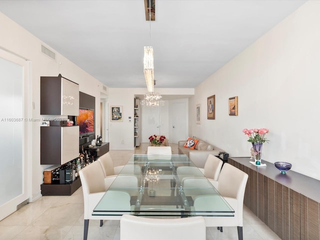 tiled dining area featuring a chandelier