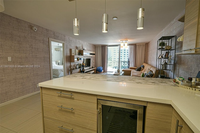 kitchen featuring hanging light fixtures, wine cooler, light brown cabinetry, and light tile floors