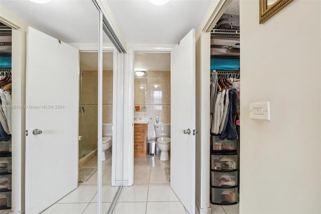 hall with tile walls and light tile floors