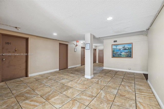 basement with tile flooring and a textured ceiling