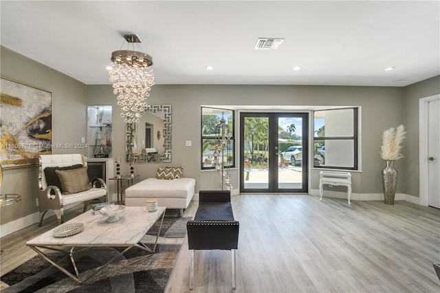 interior space with french doors, hardwood / wood-style floors, and an inviting chandelier