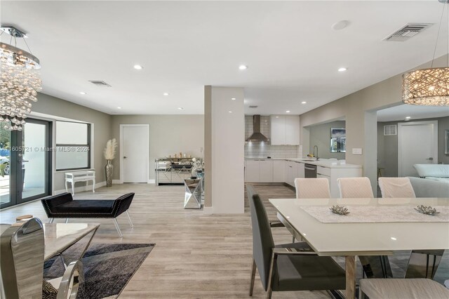 dining space with french doors, light hardwood / wood-style flooring, and sink