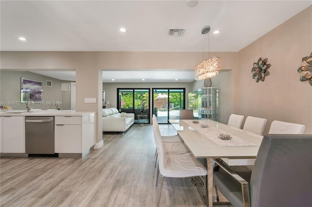 dining space featuring light wood-type flooring and sink