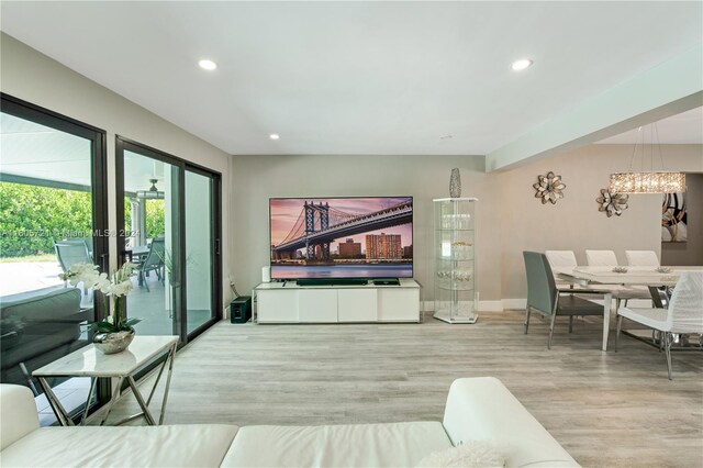 living room featuring a notable chandelier and light hardwood / wood-style flooring