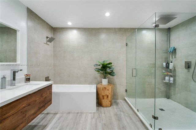 bathroom with vanity, tile walls, and plus walk in shower