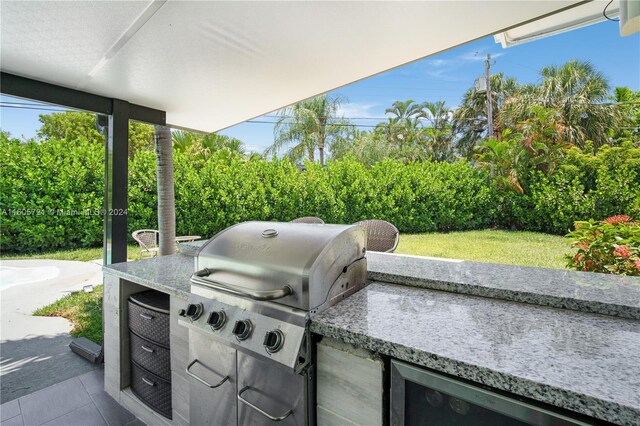 view of patio with exterior kitchen and a grill