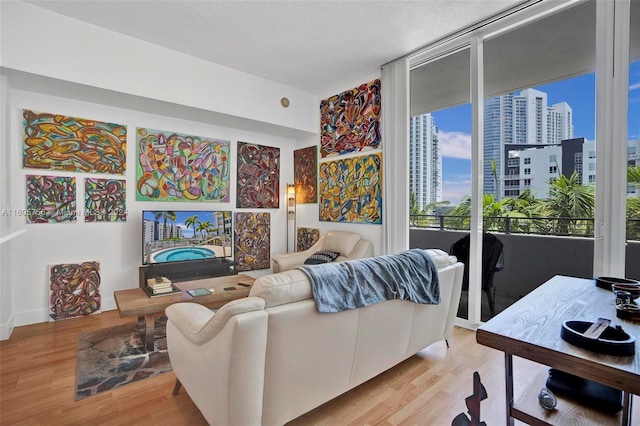 living room with a textured ceiling, light hardwood / wood-style floors, and floor to ceiling windows