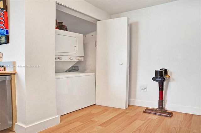 washroom featuring light hardwood / wood-style flooring and stacked washing maching and dryer