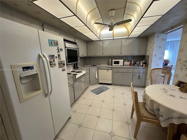 kitchen with gray cabinets, ceiling fan, sink, and white appliances