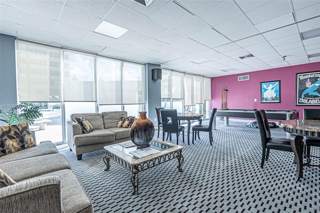 living room featuring carpet flooring, a paneled ceiling, and floor to ceiling windows