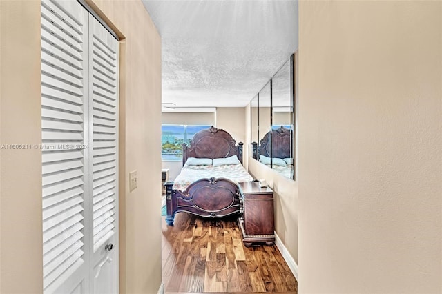 hall with a textured ceiling and hardwood / wood-style flooring