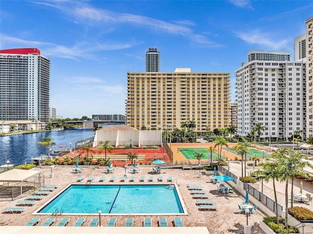 view of pool featuring a water view and a patio area