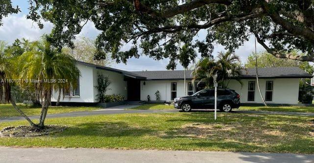 ranch-style house featuring a carport and a front yard