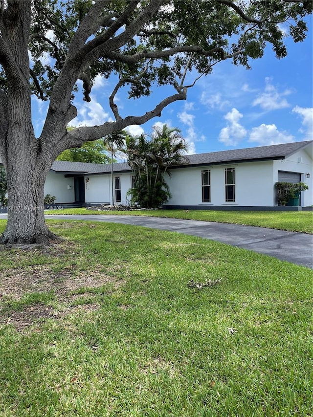 single story home featuring a front lawn