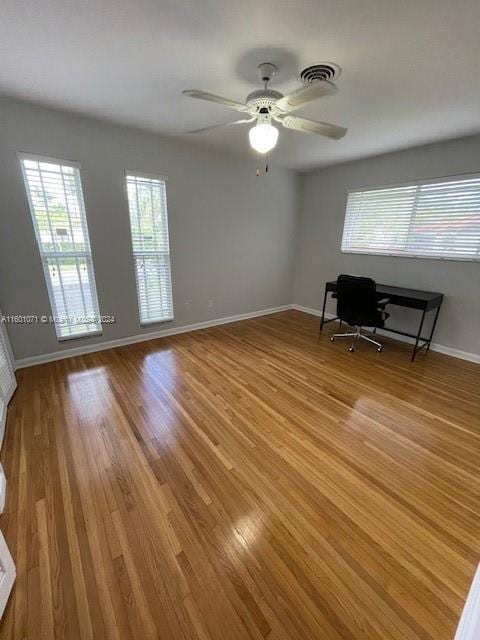 unfurnished office with ceiling fan and light hardwood / wood-style floors