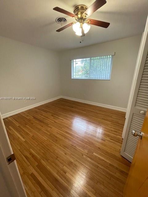 empty room with ceiling fan and hardwood / wood-style flooring