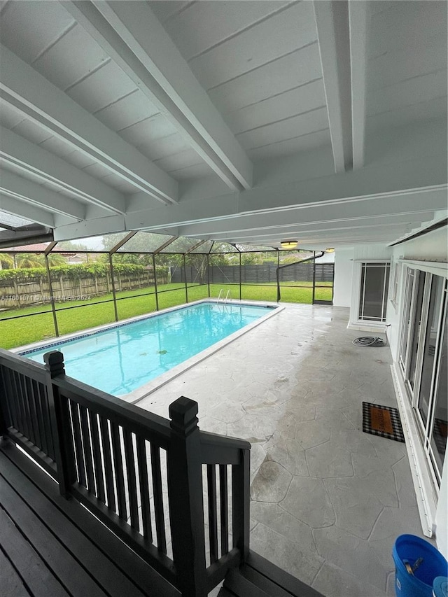 view of pool featuring glass enclosure and a lawn