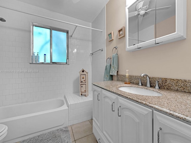 full bathroom featuring tiled shower / bath combo, toilet, vanity, tile patterned floors, and ceiling fan