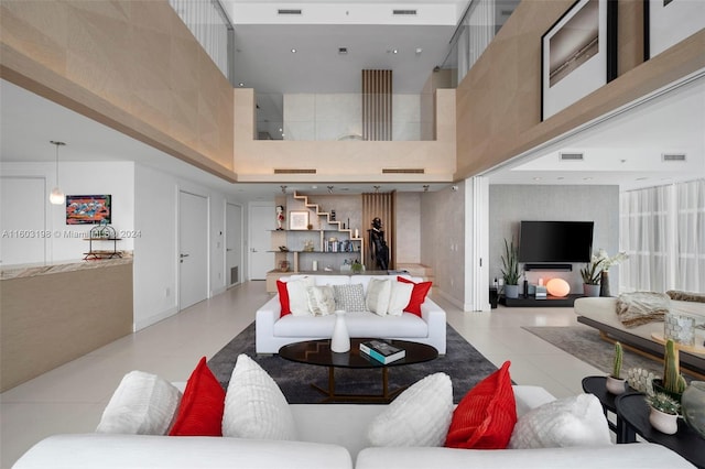 living room with a towering ceiling and light tile patterned flooring