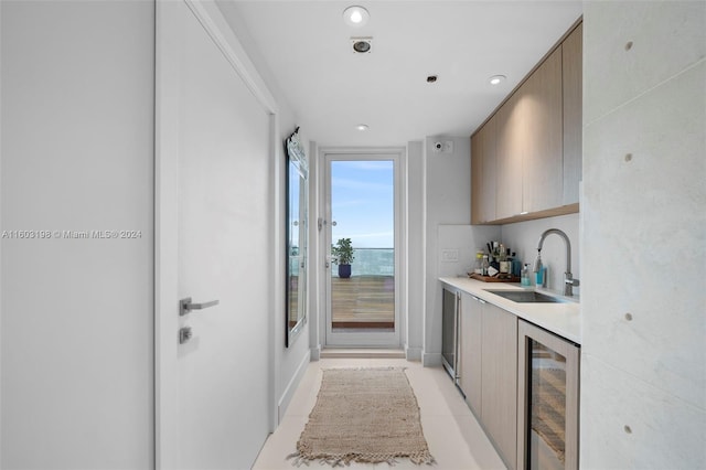 kitchen featuring light tile patterned floors, wine cooler, and sink