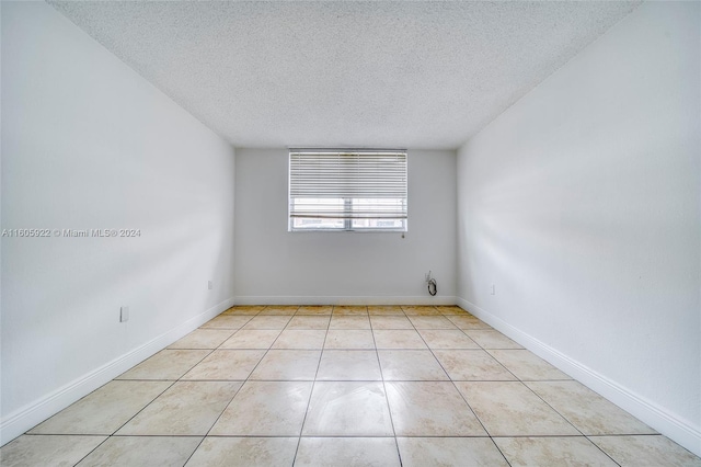 tiled spare room with a textured ceiling