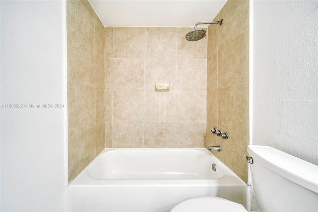 bathroom featuring tiled shower / bath and toilet