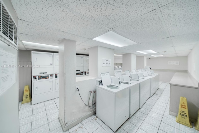 clothes washing area with stacked washer and dryer and light tile flooring