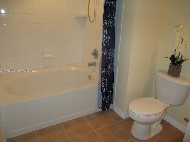 bathroom with tile floors, shower / tub combo with curtain, and toilet