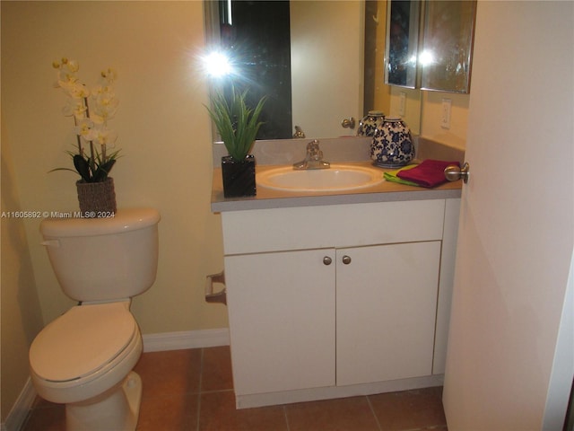 bathroom with tile flooring, vanity, and toilet