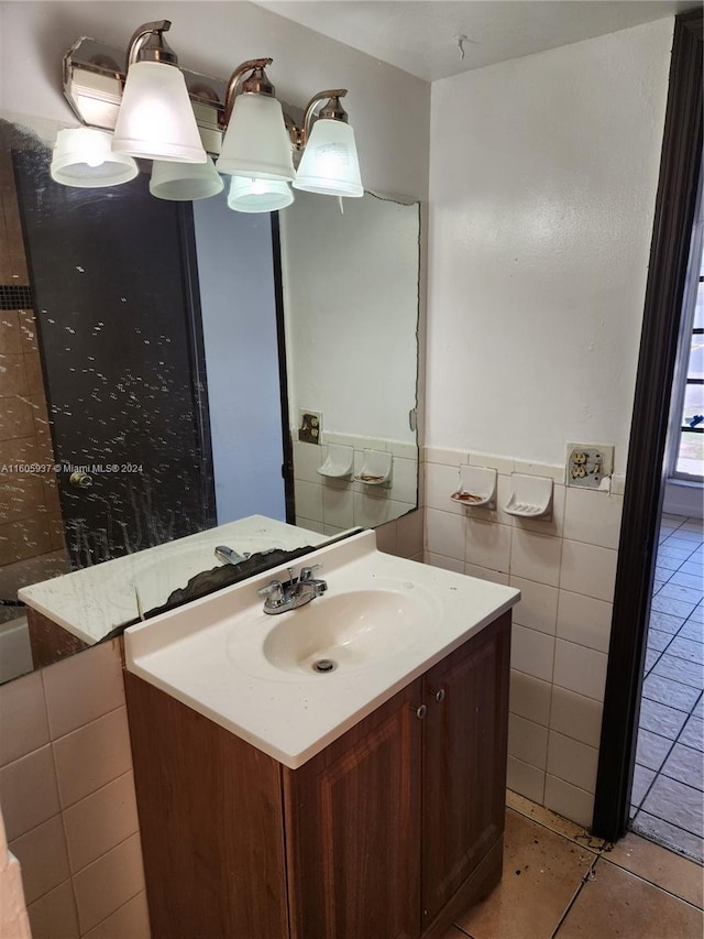 bathroom with tile flooring, vanity, and tile walls