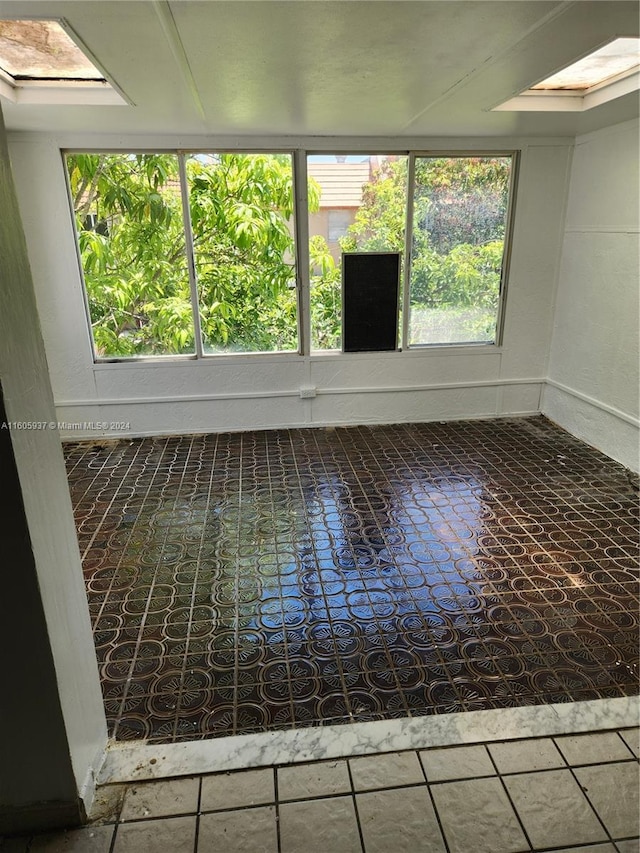 tiled empty room with a skylight