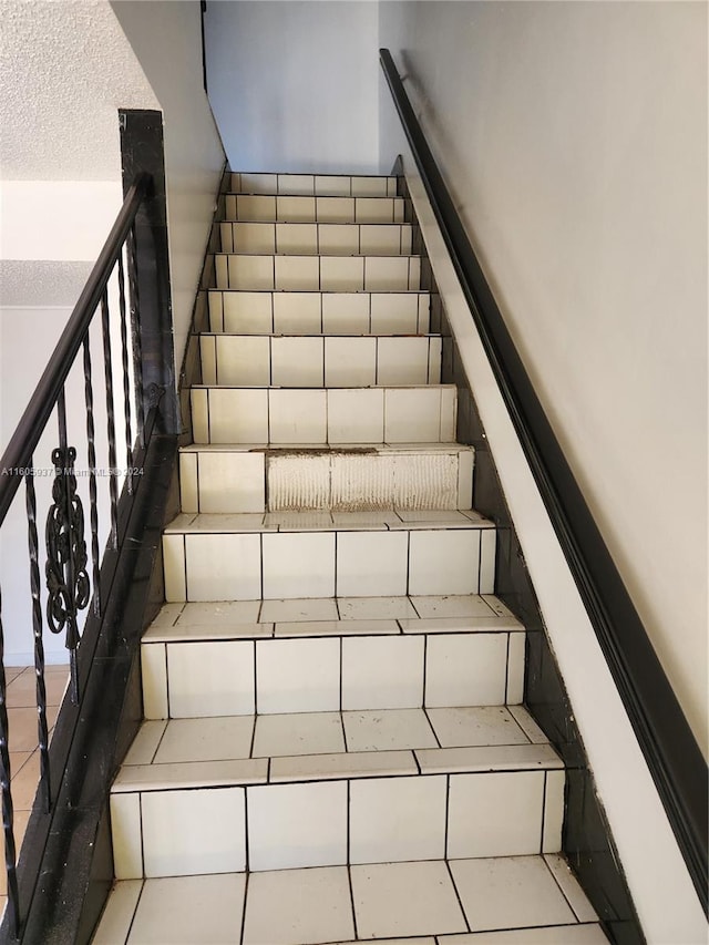 stairway featuring tile floors